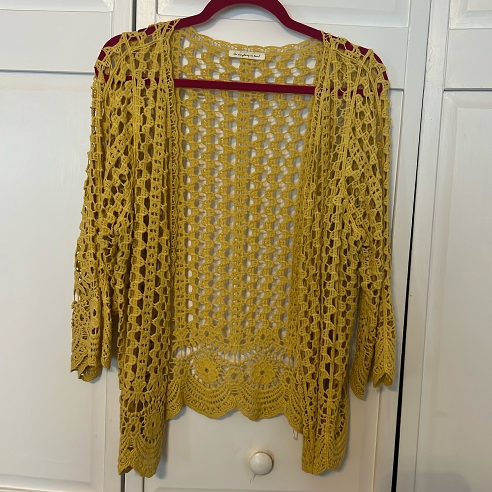 Yellow crocheted sweater with scalloped edges at the bottom and on the sleeves.